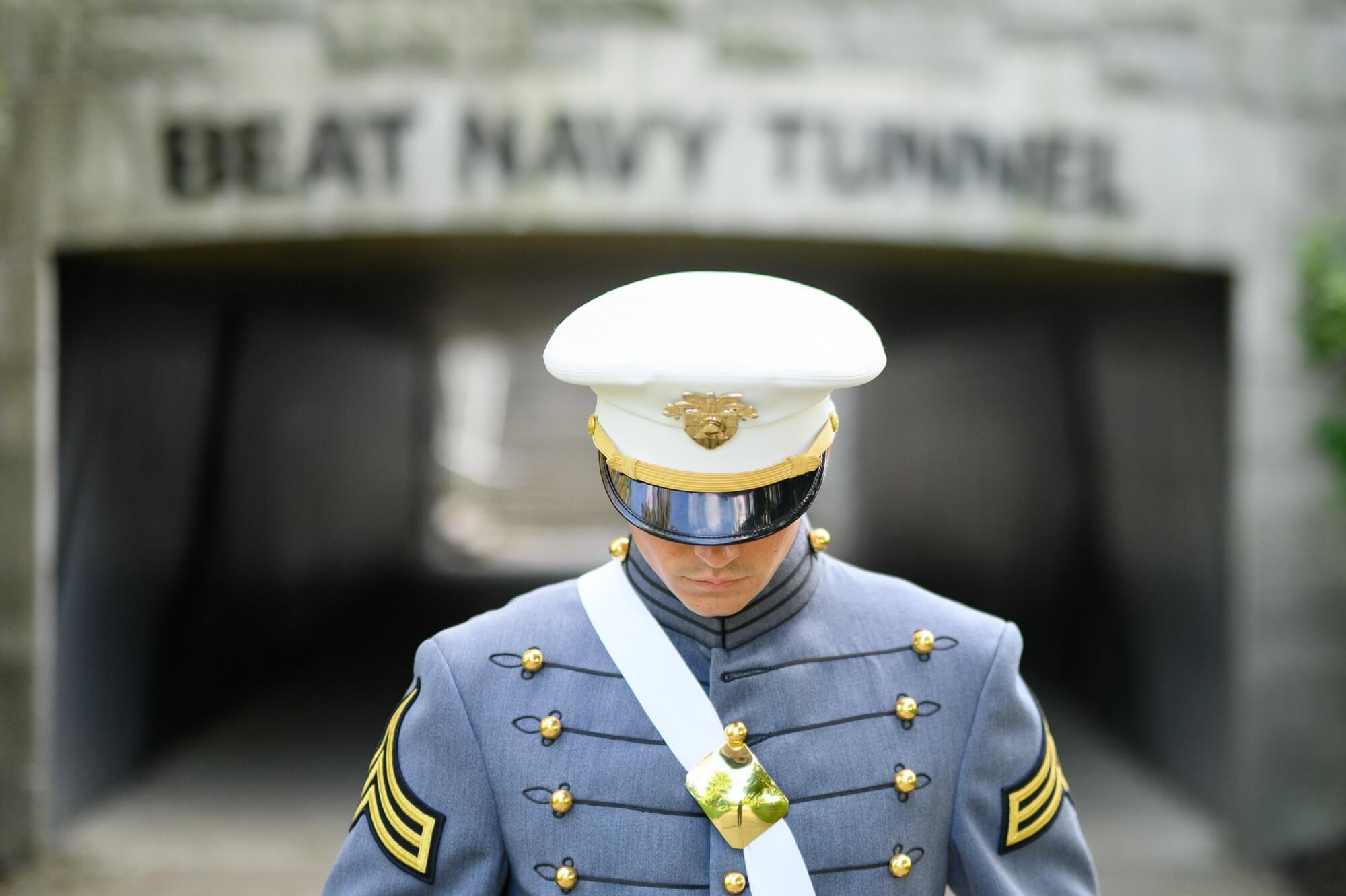 usma cadet in front of beat navy bridge